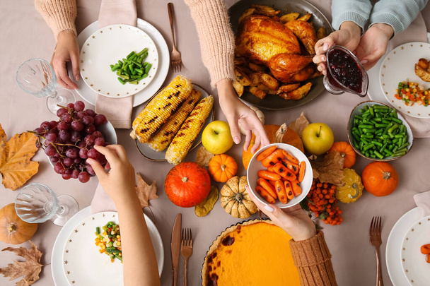 Donne con cibo gustoso sul tavolo da pranzo impostato per il giorno del Ringraziamento, vista dall'alto - Foto, immagini