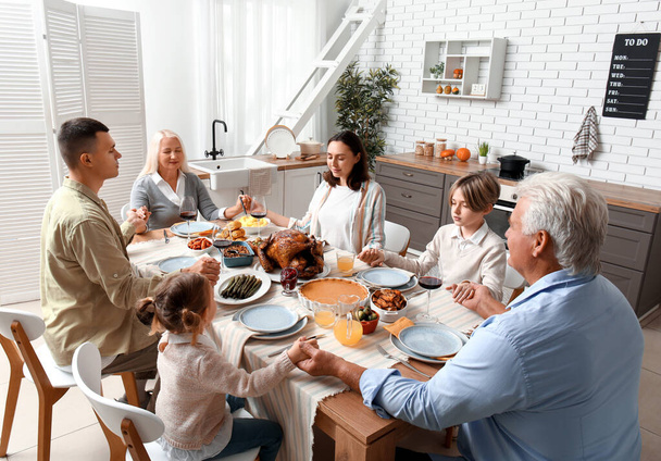 Famiglia felice che prega prima di cena a tavola festiva il giorno del Ringraziamento - Foto, immagini