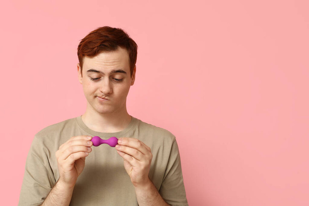 Átgondolt fiatalember anális dugó rózsaszín háttér - Fotó, kép