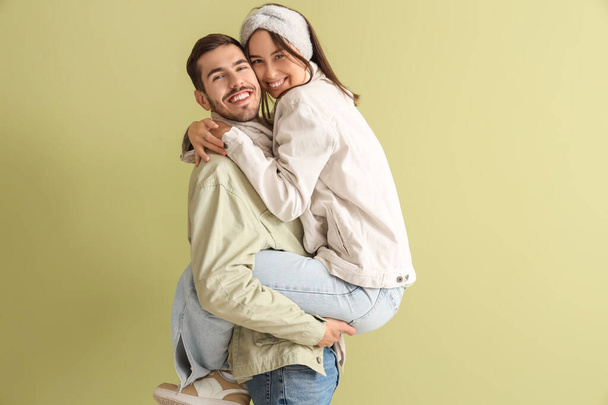 Αγαπημένο ζευγάρι σε χειμωνιάτικα ρούχα σε πράσινο φόντο - Φωτογραφία, εικόνα