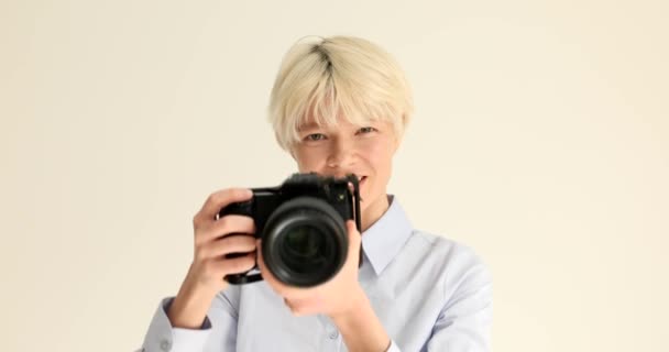 Woman photographer taking pictures on professional camera on white background portrait 4k movie slow motion. Hobby photography concept - Footage, Video
