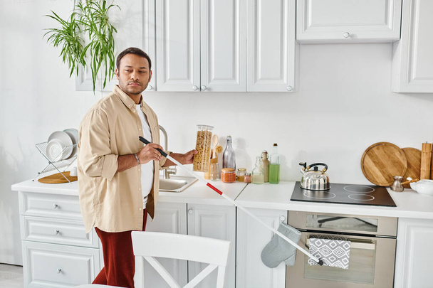 houkutteleva intialainen mies sokeus rento pukea poiminta purkki makaroni ollessaan keittiössä - Valokuva, kuva