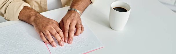 przycięty widok hinduskiego niewidomego siedzącego przy stole i czytającego kod Braille 'a, wyłączony, baner - Zdjęcie, obraz