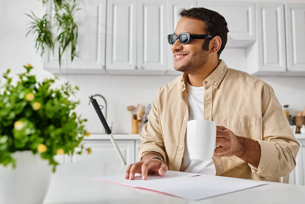 vreugdevolle blinde indiaanse man in casual kleding met koffie en wandelstok lezen braille code - Foto, afbeelding