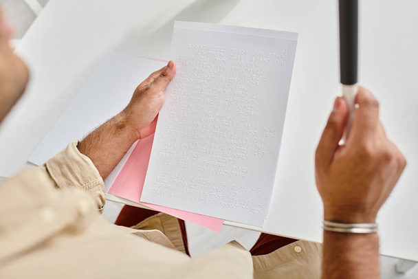 ořezaný pohled na indiána se slepotou v každodenním oblečení s vycházkovou holí čtení Braillova kódu - Fotografie, Obrázek