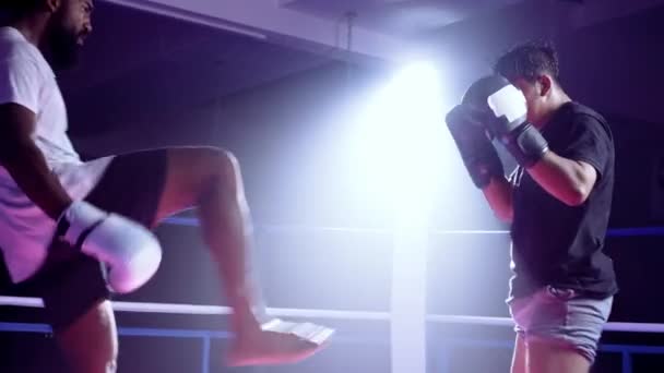 Combatientes dentro del ring participan en la pelea de boxeo Muay Thai. rival patada oponente - Metraje, vídeo