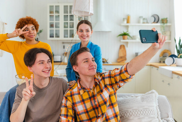Keyfinize bakın. Mutlu arkadaş grubu selfie çekiyor. Partide arkadaşlarının fotoğrafını çeken bir adam. Telefonda fotoğraf çeken bir grup çok ırklı genç. Gençler gülümsemenin keyfini çıkarırlar. - Fotoğraf, Görsel