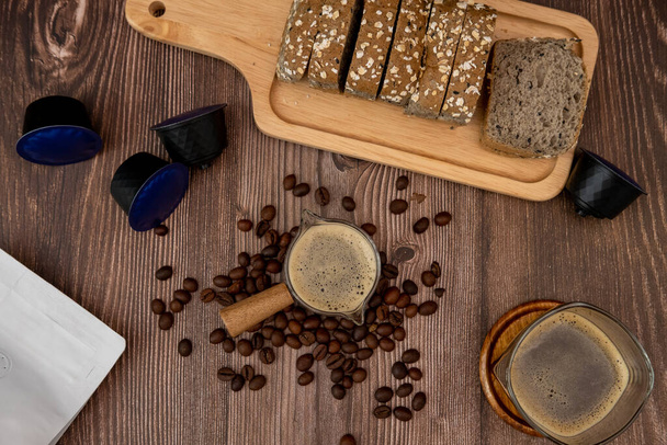 Top view, coffee cup, coffee flavored bread slices with coffee beans around - Photo, Image