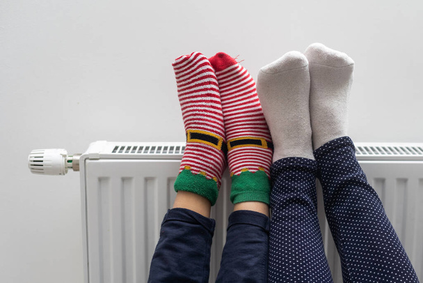 Οικογενειακή θέρμανση πόδια κοντά θερμάστρα στο σπίτι, closeup. - Φωτογραφία, εικόνα