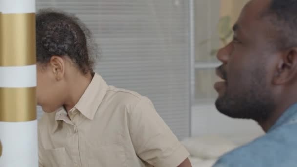 Kleines afroamerikanisches Mädchen zeigt auf Raketenteile und diskutiert mit Lehrerin während des Unterrichts - Filmmaterial, Video