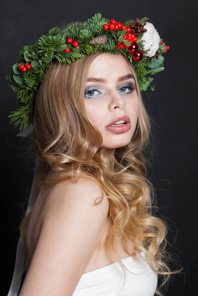 Χριστουγεννιάτικη όμορφη γυναίκα. Πανέμορφο μοντέλο με μακιγιάζ, καθαρό φρέσκο δέρμα, κυματιστά ξανθά μαλλιά, τέλειο χαμόγελο και χριστουγεννιάτικη διακόσμηση - Φωτογραφία, εικόνα