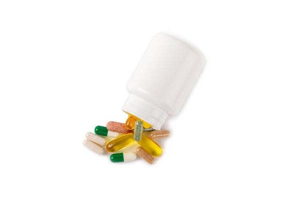 Vitaminen en supplementen. Een verscheidenheid aan vitaminetabletten in een pot geïsoleerd op een witte achtergrond. Multivitamine complex voor elke dag. Voedingssupplementen. Plaats voor tekst. Kopieerruimte. - Foto, afbeelding