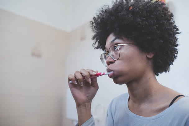 giovane donna razza mista spazzolatura interna denti - Foto, immagini
