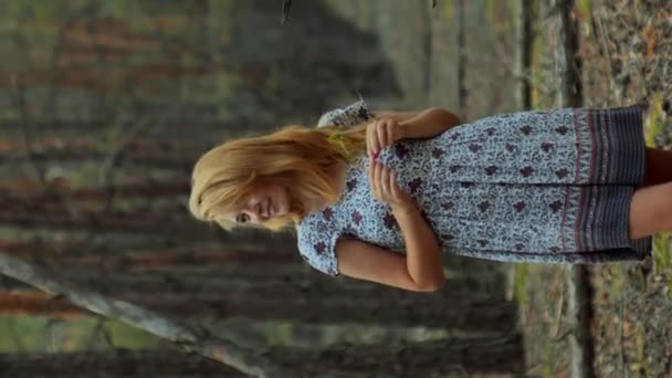 Τρυφερή γυναίκα με καλοκαιρινό φόρεμα που περπατάει στο δάσος απολαμβάνοντας την κάθετη ζωή - Πλάνα, βίντεο