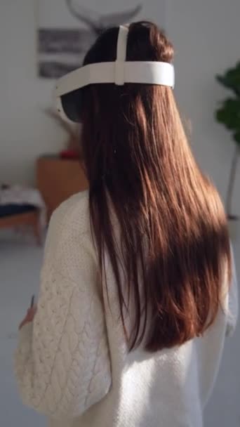 Ein attraktives junges Mädchen betrachtet mit einer Virtual-Reality-Brille einen Weihnachtsbaum. Hochwertiges 4k Filmmaterial - Filmmaterial, Video