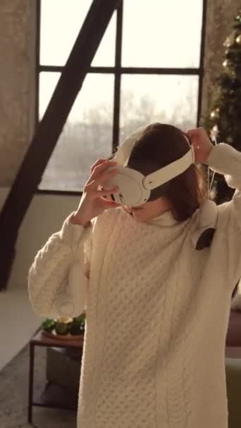 Una joven atractiva está explorando un árbol de Navidad a través de la lente de las gafas de realidad virtual. Imágenes de alta calidad 4k - Metraje, vídeo