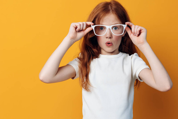 Beauty expression emotion glasses female person pretty childhood face girl white children background yellow little young small portrait model cute kid caucasian - Photo, Image