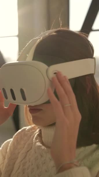 A charming young lady is viewing a Christmas tree with the aid of virtual reality glasses. High quality 4k footage - Footage, Video