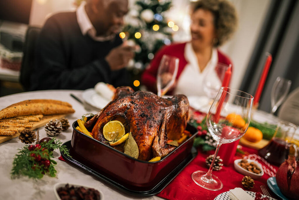 Paahdettu kalkkuna tarjoillaan ruokapöydässä perheen joulupäivälliselle. - Valokuva, kuva