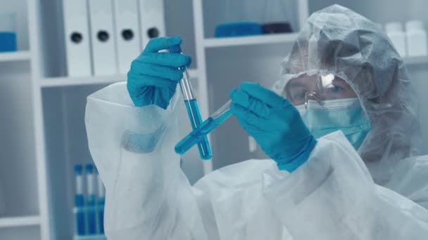 Video upozorňuje na hrdinství lékařů a vědců bojujících proti virům a vyvíjejících léky. Portrét odvážného ženského lékaře s zkumavkami pracující v laboratoři, s lékařským oděvem a - Záběry, video