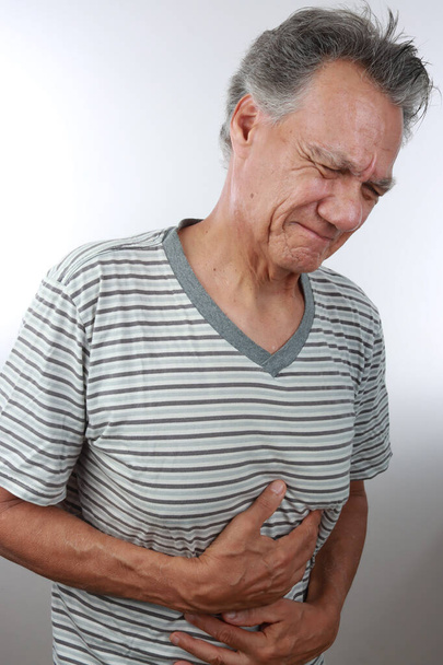 Older Mature man holding his stomach because of pain - Photo, Image