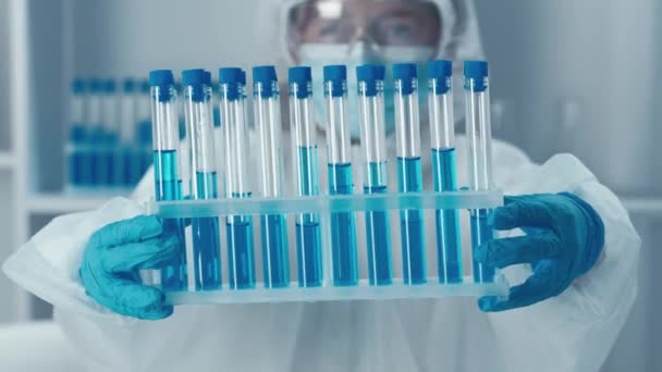 Вчений у хімічній лабораторії. Відео фокусується на генетичних дослідженнях, використанні технології ДНК та розробці нових препаратів для покращення здоров'я людини. процес розробки вакцин - Кадри, відео