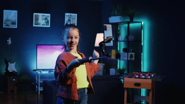 ウイルス性ダンス振付を行うためにセルフィースティックに接続された携帯電話を使用して,他のオンライン遺伝子Z子供からのビューやエンゲージメントを生成するコンテンツを作成する若い才能のある子供 - 映像、動画