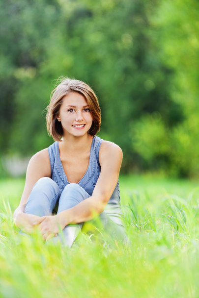Young woman sitting grass - Фото, изображение