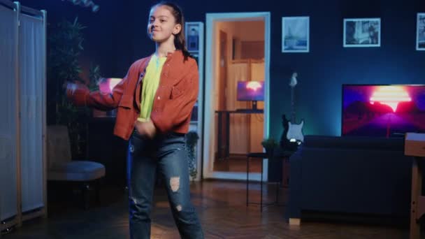 Zoom in and out shot of talented kid getting tons of engagement on her dancing clips posts σε πλατφόρμες κοινωνικής δικτύωσης. Παιδί αστέρι των μέσων ενημέρωσης κινηματογραφεί ιογενή βίντεο, εντυπωσιάζει το κοινό με χορευτικές κινήσεις - Πλάνα, βίντεο