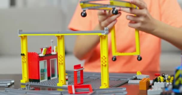 Bambino ragazzo che gioca e costruisce con mattoni di plastica colorati al tavolo. Apprendimento precoce e sviluppo. Filmati 4k di alta qualità - Filmati, video