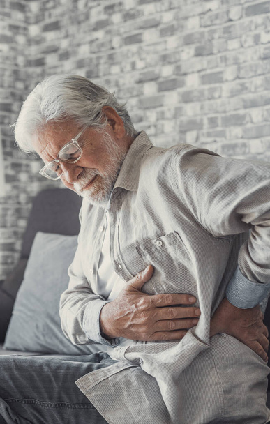 Постраждалий старший чоловік відчуває раптовий біль у спині біль напруга, що сидить вдома, сумний старий дідусь торкається хребта, який має нижній біль у попереку остеоартрозний артрит, концепція бека
 - Фото, зображення