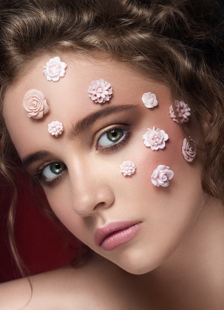 Romantic nude young beautiful girl with white flowers on her face and soft curls on dark background - Foto, Imagem