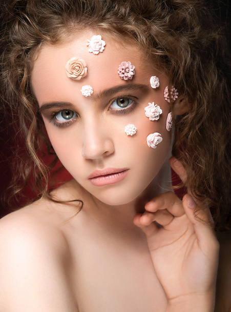 Romantic nude young beautiful girl with white flowers on her face and soft curls on dark background. - Φωτογραφία, εικόνα