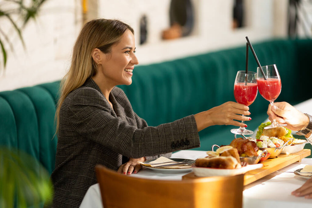 Giovane coppia che pranza e beve succo fresco spremuto nel ristorante - Foto, immagini