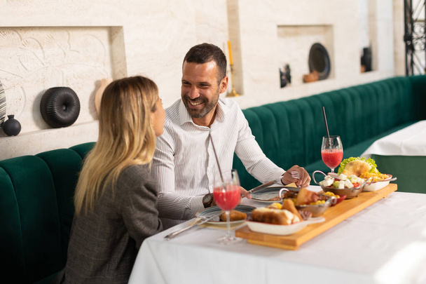 Jovem casal almoçando e bebendo suco fresco espremido no restaurante - Foto, Imagem