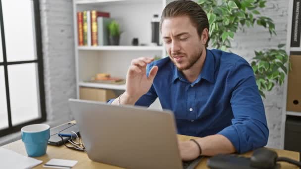 Giovane ispanico uomo d'affari stressato utilizzando il computer portatile in ufficio - Filmati, video