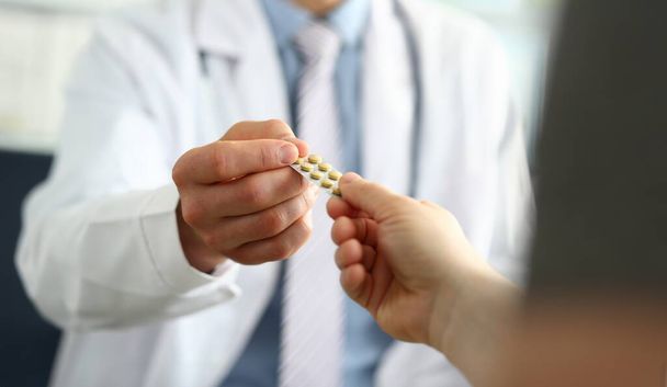 医者の手を閉じて患者に薬を与える。病気の概念の患者に薬を処方 - 写真・画像