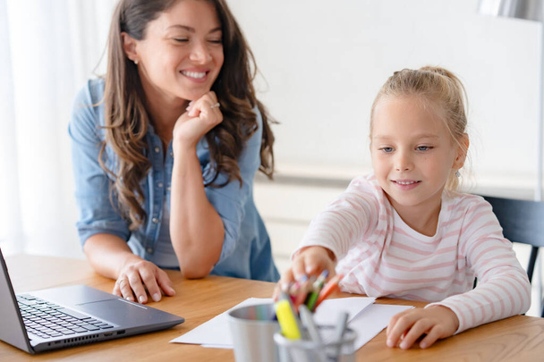 glückliche Mutter und Tochter, die zu Hause gemeinsam lernen, Online-Bildung - Foto, Bild