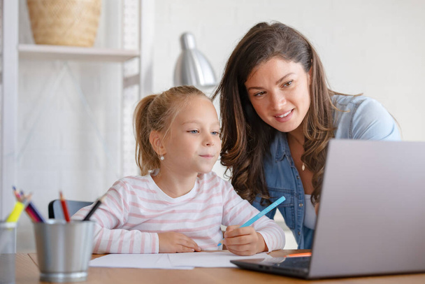 szczęśliwa matka i córka studiuje razem w domu, edukacja online - Zdjęcie, obraz