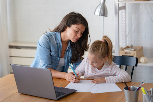 happy mother and daughter studying together at home, online education - Photo, Image
