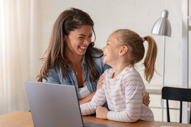 ευτυχισμένη μητέρα και κόρη σπουδάζουν μαζί στο σπίτι, online εκπαίδευση - Φωτογραφία, εικόνα