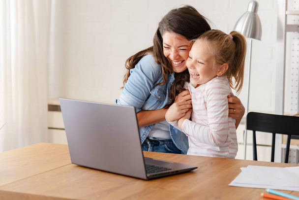 ευτυχισμένη μητέρα και κόρη σπουδάζουν μαζί στο σπίτι, online εκπαίδευση - Φωτογραφία, εικόνα
