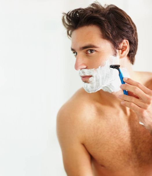 Bőrápolás, borotválkozás és borotválkozás egy férfival az otthona fürdőszobájában ápolásért vagy reggeli rutinért. Arc, szépség és hab egy fiatalemberrel a lakásában, hogy leborotválja a szakállát a szőrtelenítéshez.. - Fotó, kép