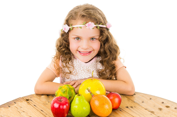 Cute little preschooler girl with fruits on the table - Fotografie, Obrázek