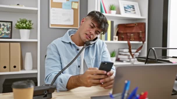 Atraente, hispânico trabalhador de escritório masculino absorvido em conversa de negócios séria em seu smartphone, navegando no mundo corporativo de seu local de trabalho elegante - Filmagem, Vídeo