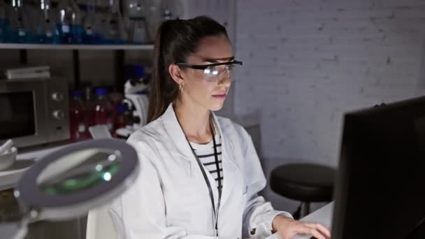 Policzki nadęte, młoda i piękna latynoska naukowiec kobieta robi zabawną twarz, nadmuchiwanie jej usta powietrzem podczas wstrzymywania oddechu w laboratorium - Materiał filmowy, wideo