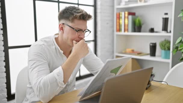Huolestunut nuori valkoihoinen mies, stressaantunut toimistotyöntekijä tuskissaan, työasiakirjojen lukeminen, stressaavaa työtä särkee - Materiaali, video