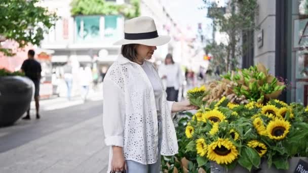 Stockholm sokaklarındaki çiçeklere gülümseyen güzel İspanyol kadın. - Video, Çekim