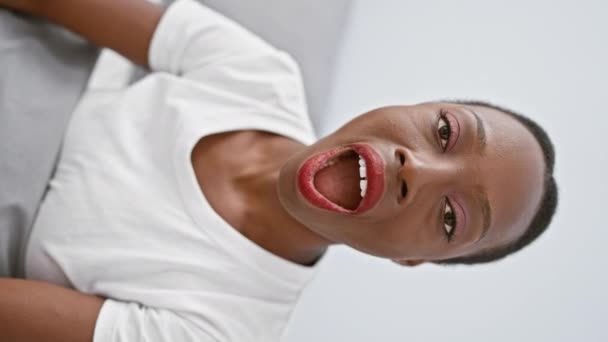 Vonzó afro-amerikai nő fekszik a kényelmes hálószoba ágy, puffadt arc szórakoztató kifejezés, hogy egy őrült vicces arc, száj tele levegővel - Felvétel, videó