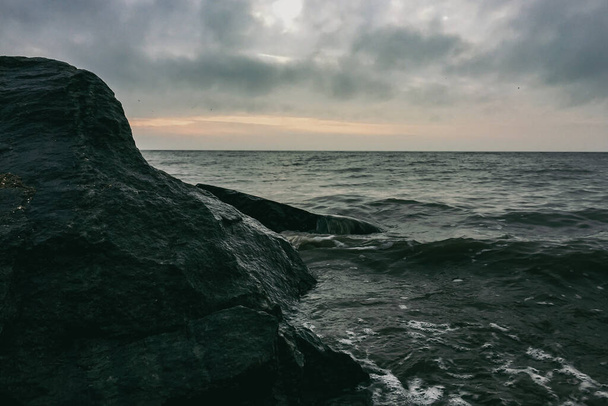 Βαριά κύματα μολύβδου πέφτουν πάνω στα βράχια. - Φωτογραφία, εικόνα